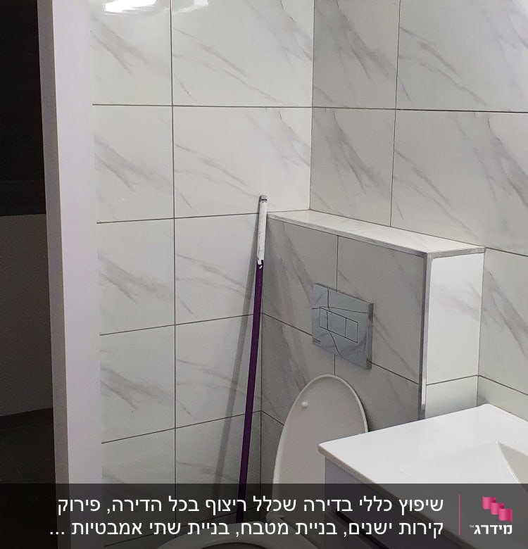 שירותים עם אריחים לבנים ומקל לניקוי